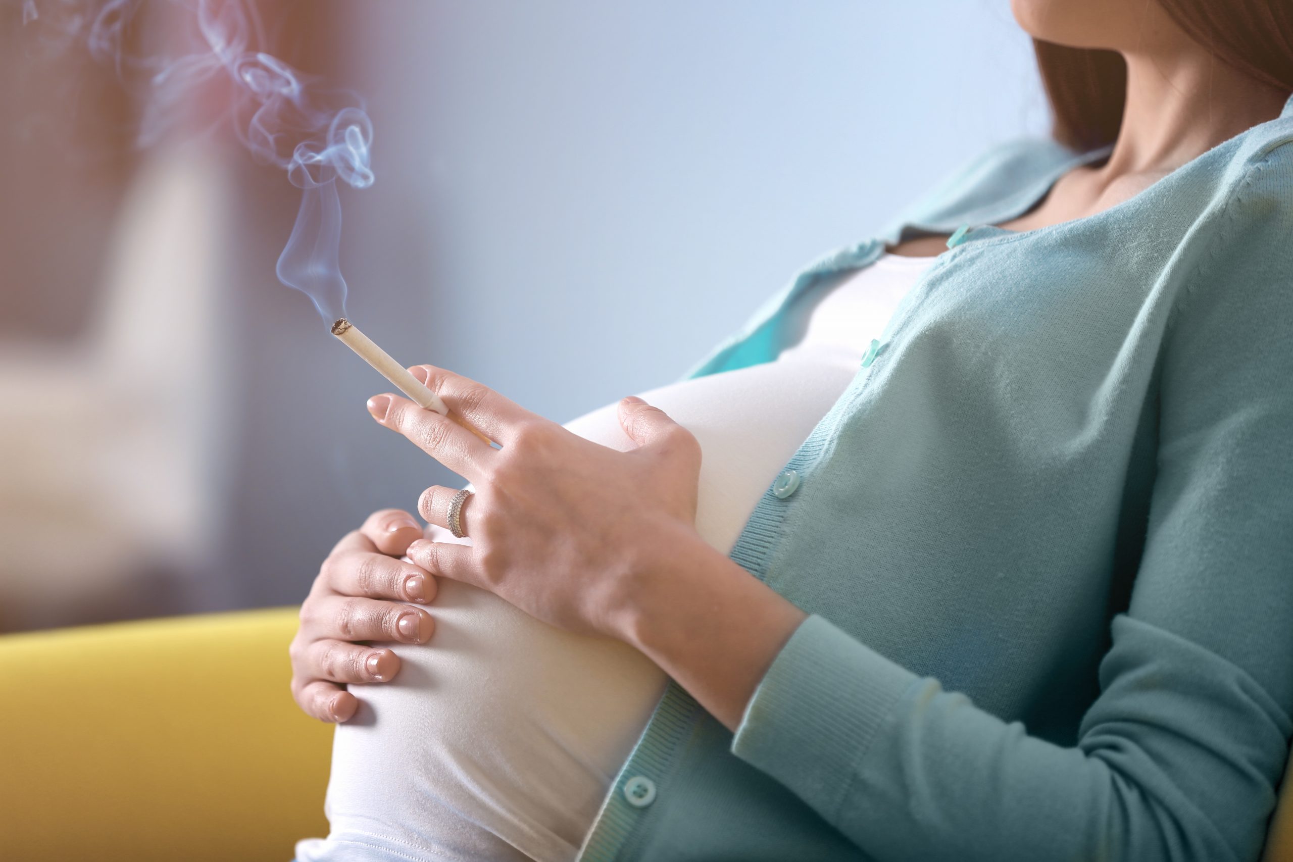 schwangere Frau mit Zigarette in der Hand