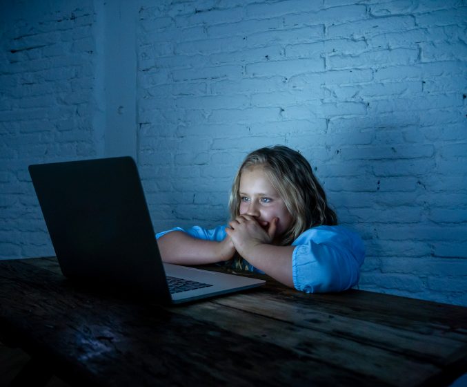 verängstigtes Mädchen vor Laptop