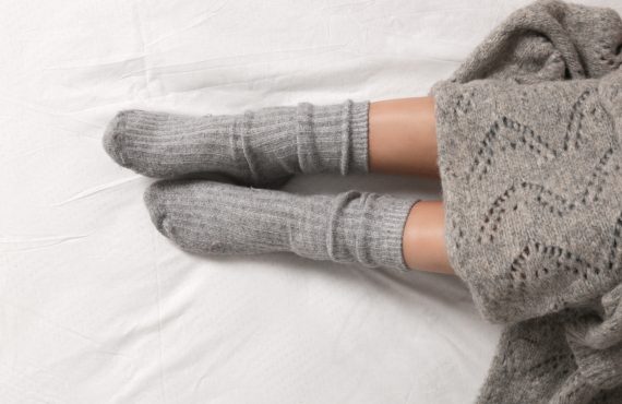 weibliche Füße mit grauen Socken aus Kaschmirwolle