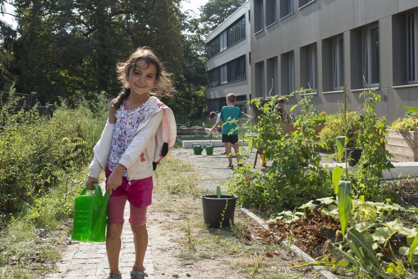 Mädchen mit Gießkanne im Schulgarten