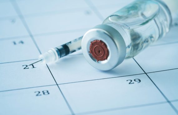 Spritze und Impfstoff im Kalender