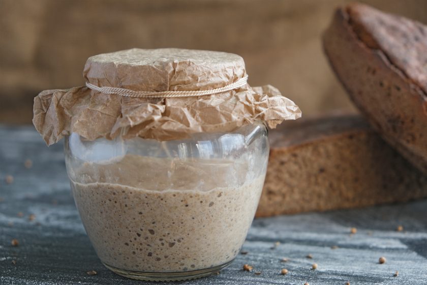 frischer Roggensauerteig im Glas und Laib Vollkornbrot